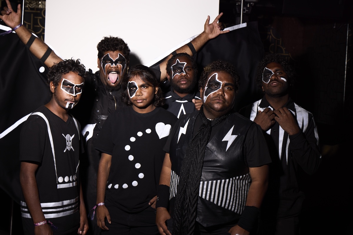 Aboriginal rock band Mulga Bore Hard Rock pose in black-and-white face paint and themed outfits inspired by KISS.